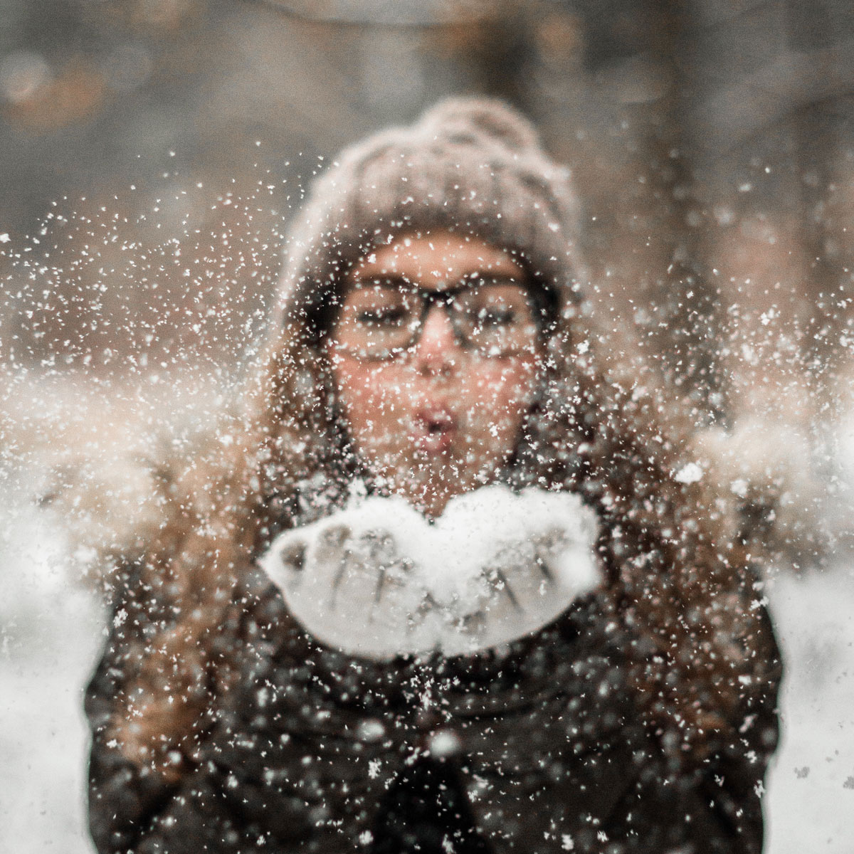 A woman blowing snow.
